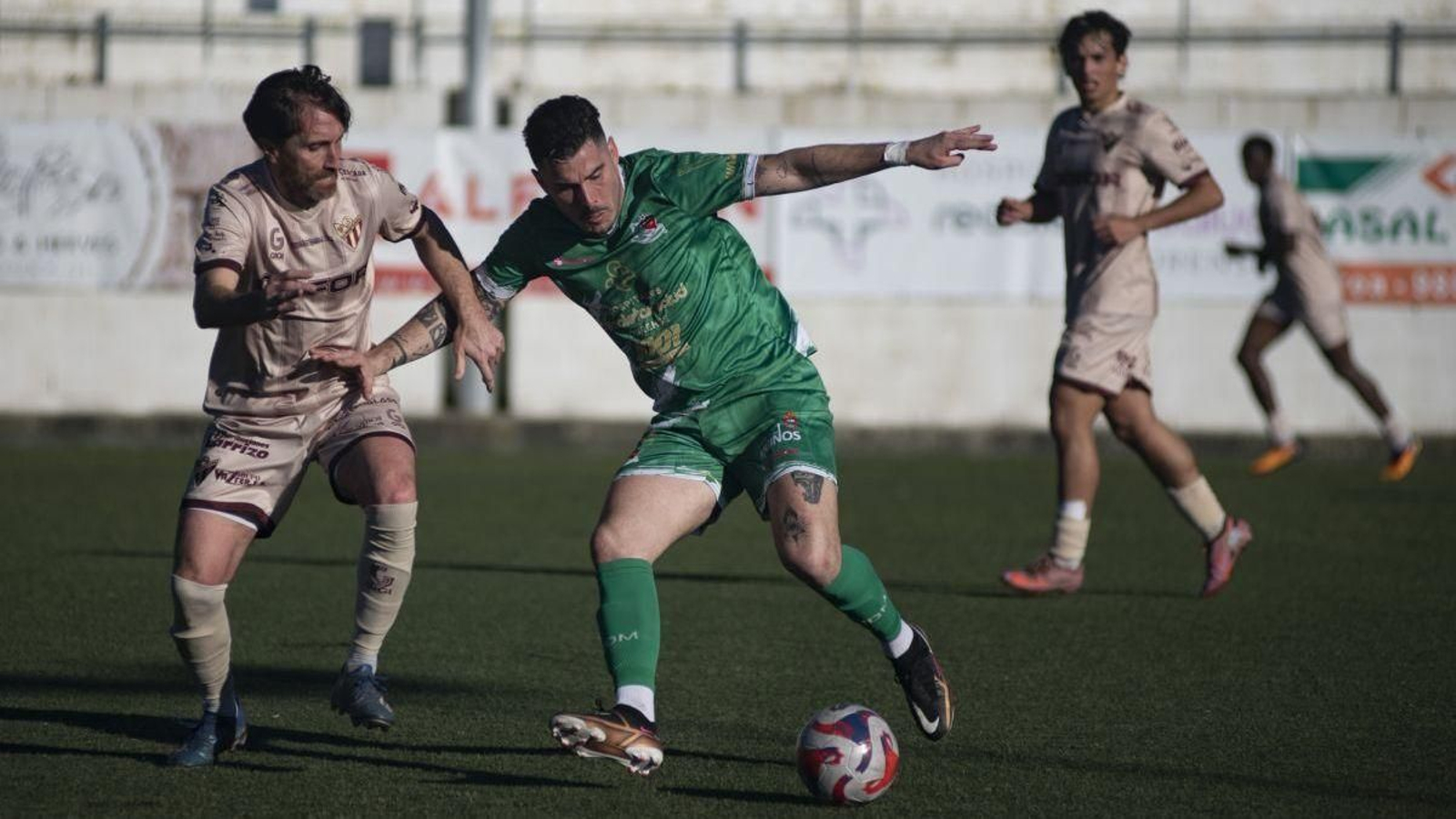 Álex Fernández, del Muíños, protege el balón ante Rubén García, del Córgomo.