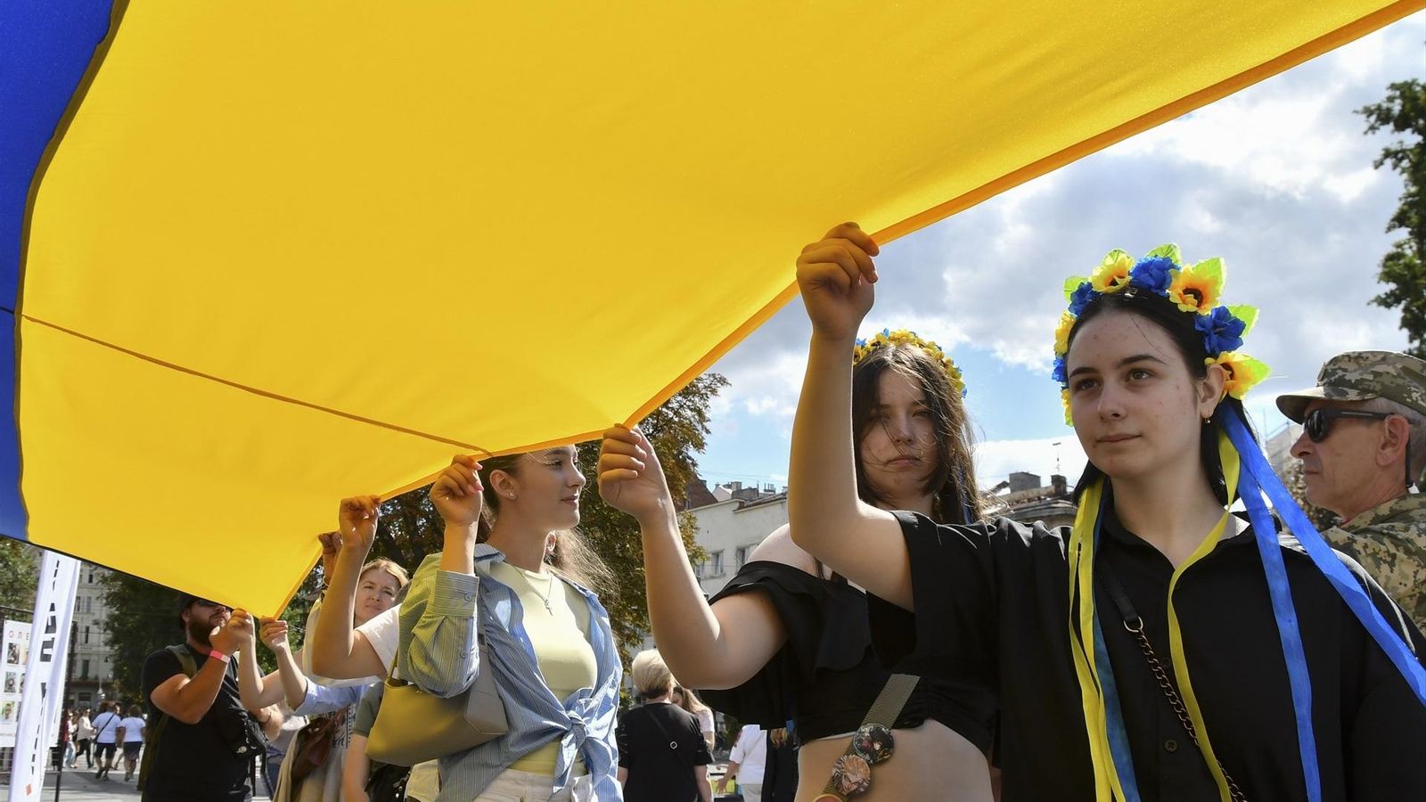 Jóvenes ucranianas marchan portando la bandera