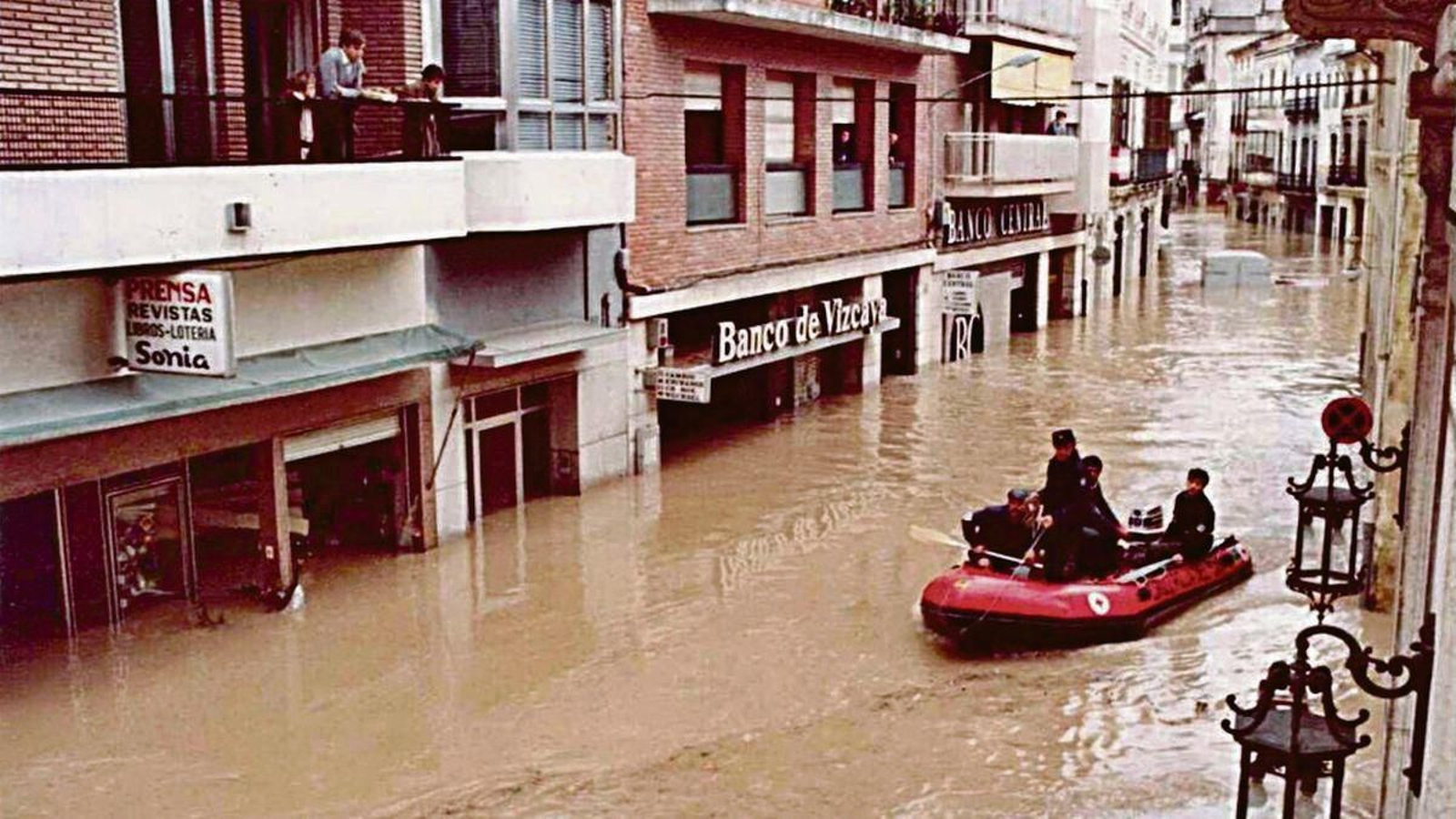 Una barca navega las calles inundadas por el agua de Júcar.