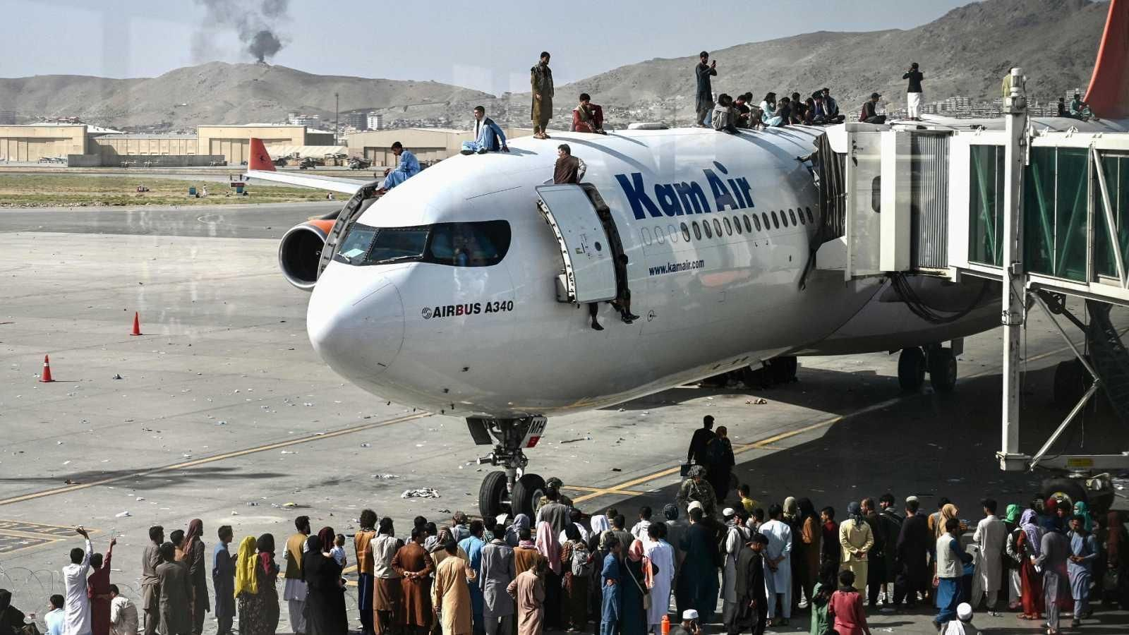 Decenas de afganos intentan subirse a un avión de la aerolínea Kam Air, en el aeropuerto de Kabul.