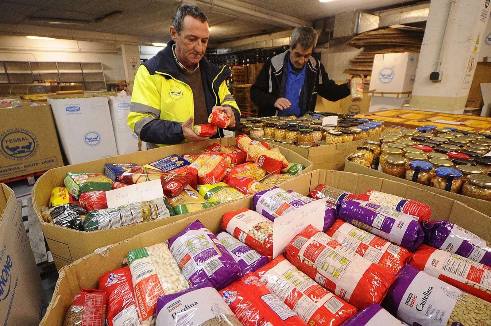 Los voluntarios Miguel y José Manuel trabajando en el banco de alimentos

Fotos Martiño Pinal