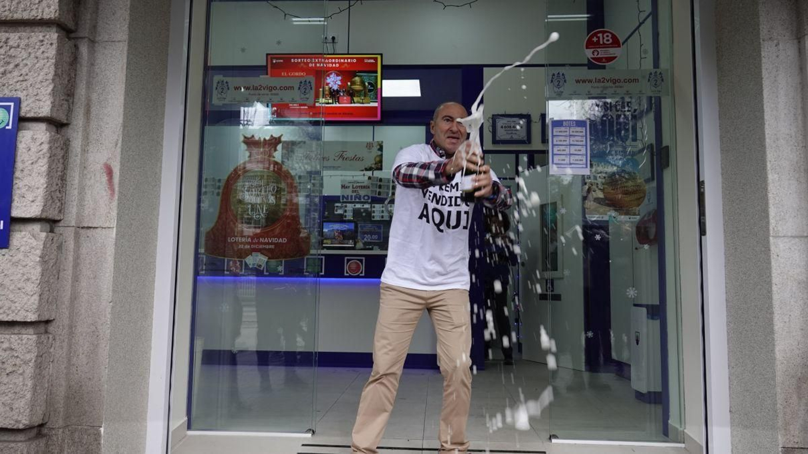 Pablo Áreas, lotero de la administración número dos de Gran Vía, celebra con champán repartir el primer premio.
