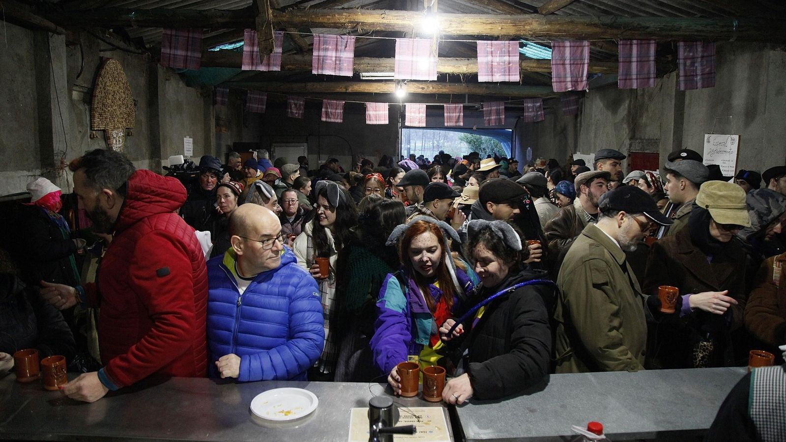 Los presentes, refugiándose de la lluvia en la “palleira”.