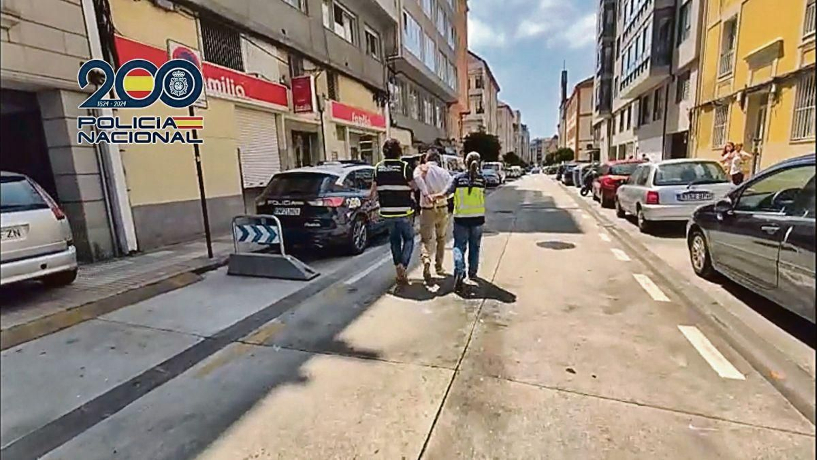 Dos agentes de la Policía detienen a uno de los sospechosos durante la operación llevada a cabo en A Coruña.