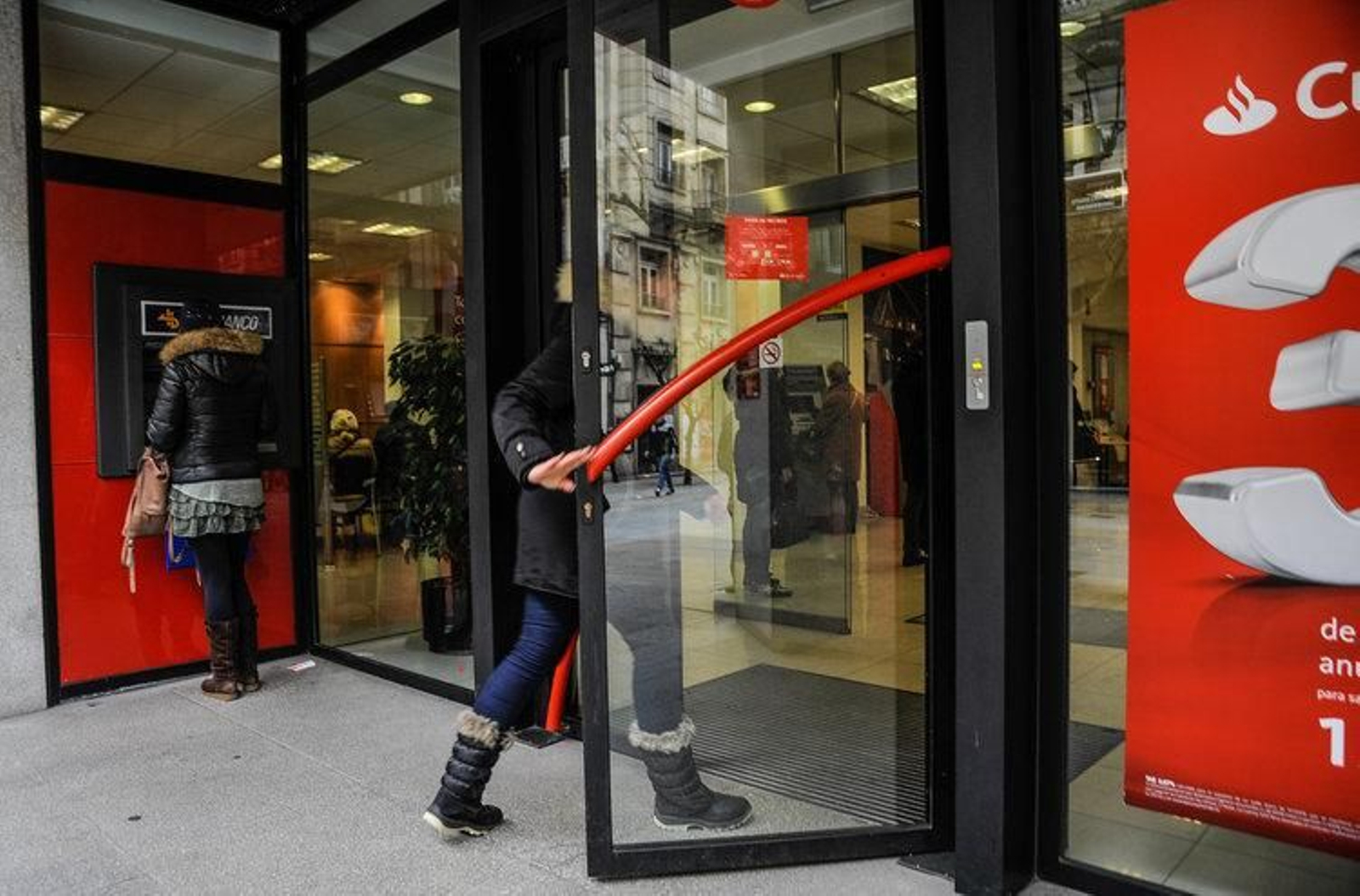 Dos clientes a las puertas de una entidad bancaria de la ciudad.