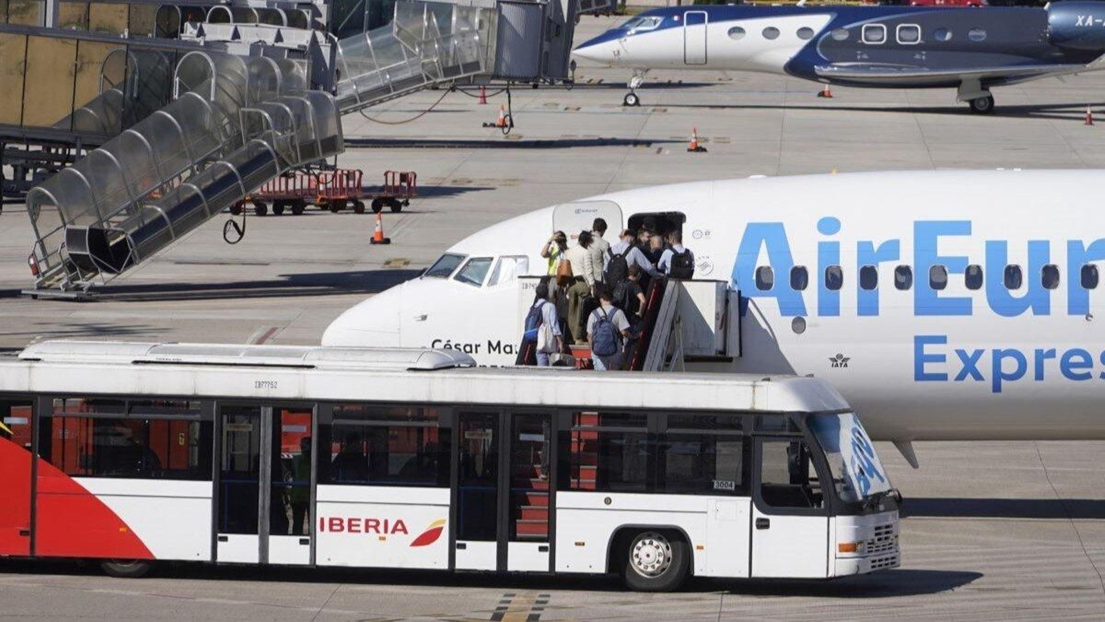 Un autobús con el logotipo de Iberia, embarcando pasajeros a un Air Europa, competencia en la ruta Vigo-Madrid.