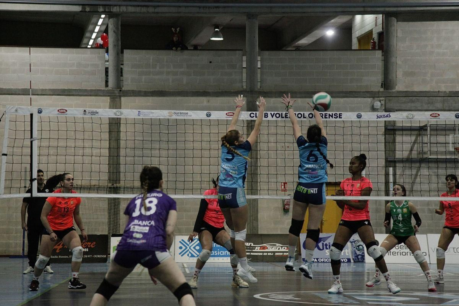 Las jugadoras del Voley Ourense intentan ganar un punto en la red en un encuentro en  O Pompeo.