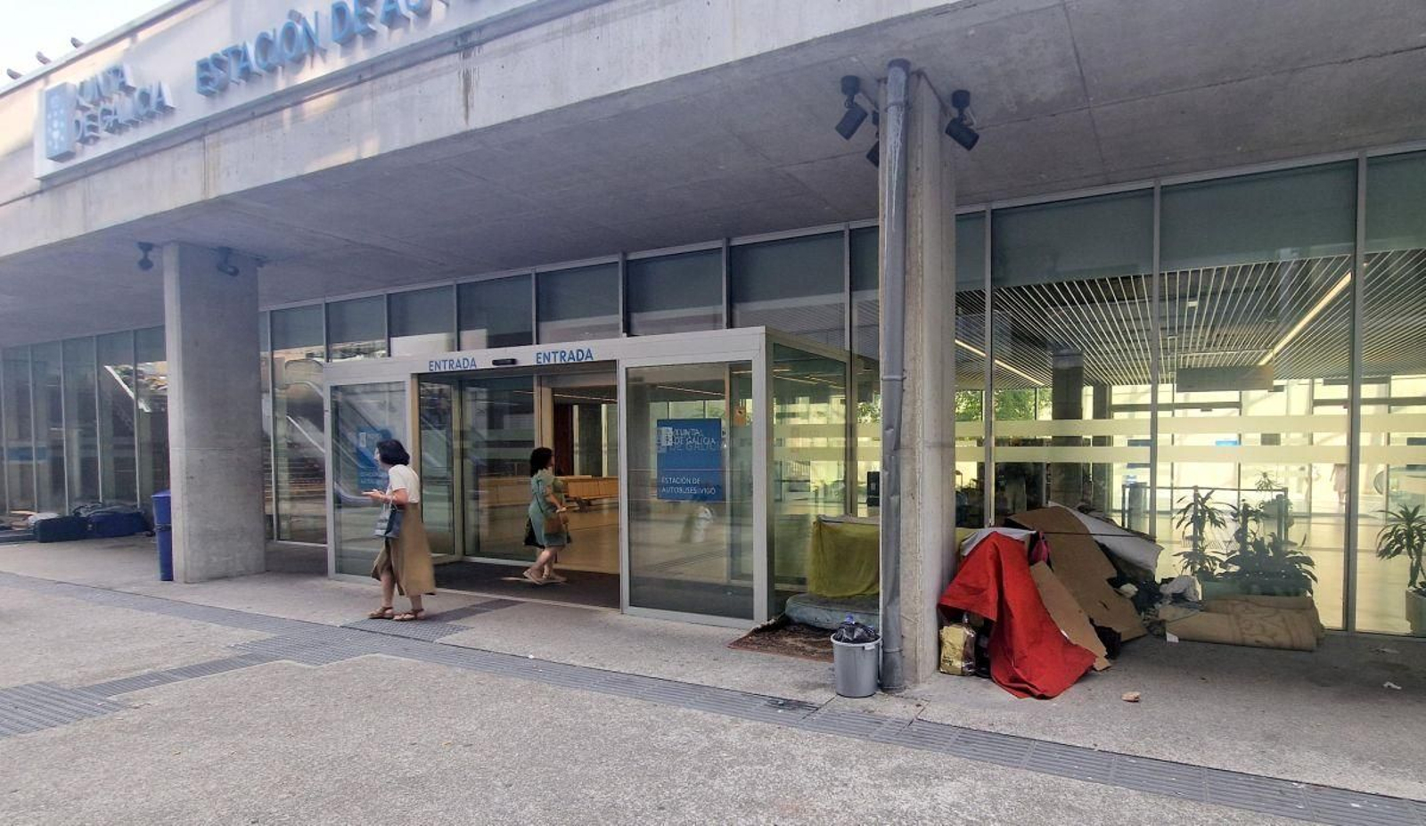 La entrada de la nueva estación de autobuses, con varios colchones en el suelo y cartones para construir un pequeño espacio para dormitar