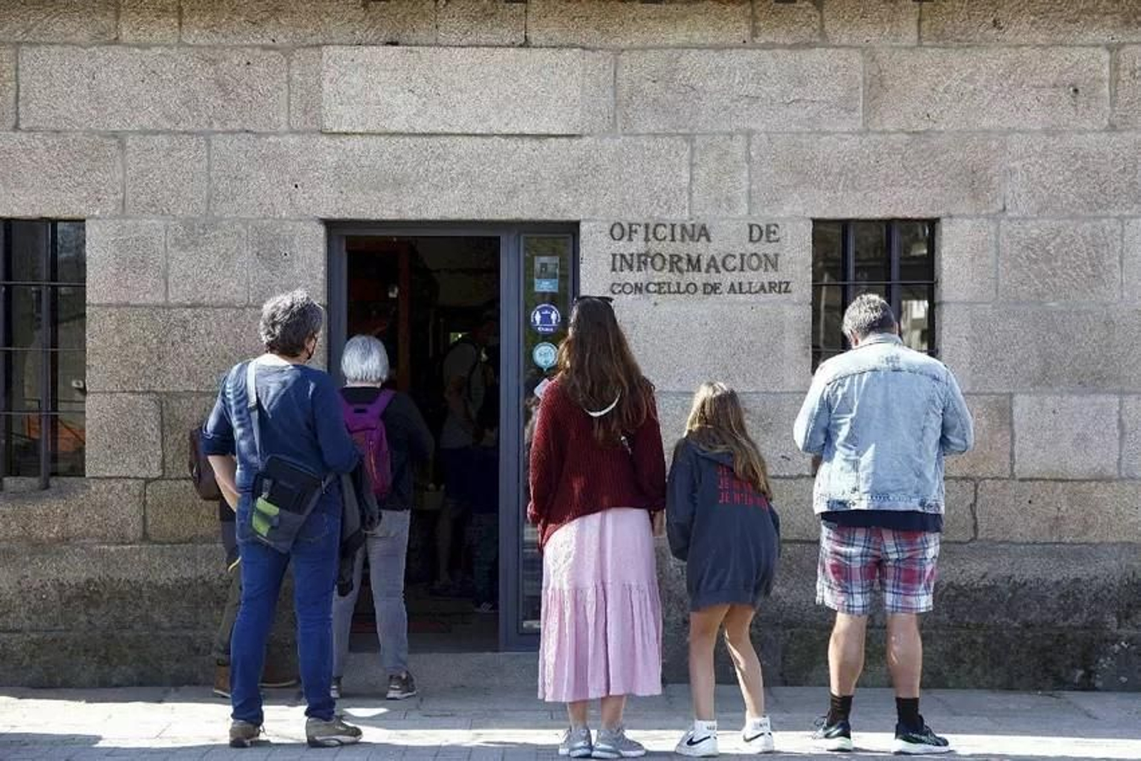 Un grupo de turistas delante de la oficina de información alaricana.