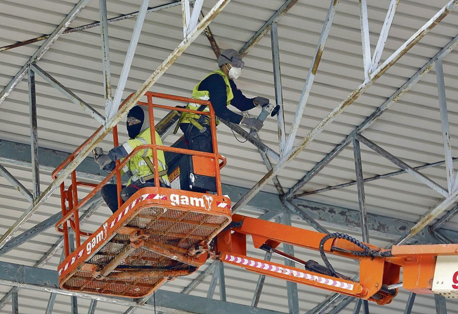 Dos operarios realizan trabajos en altura en la construcción, uno de los sectores más masculinizados.