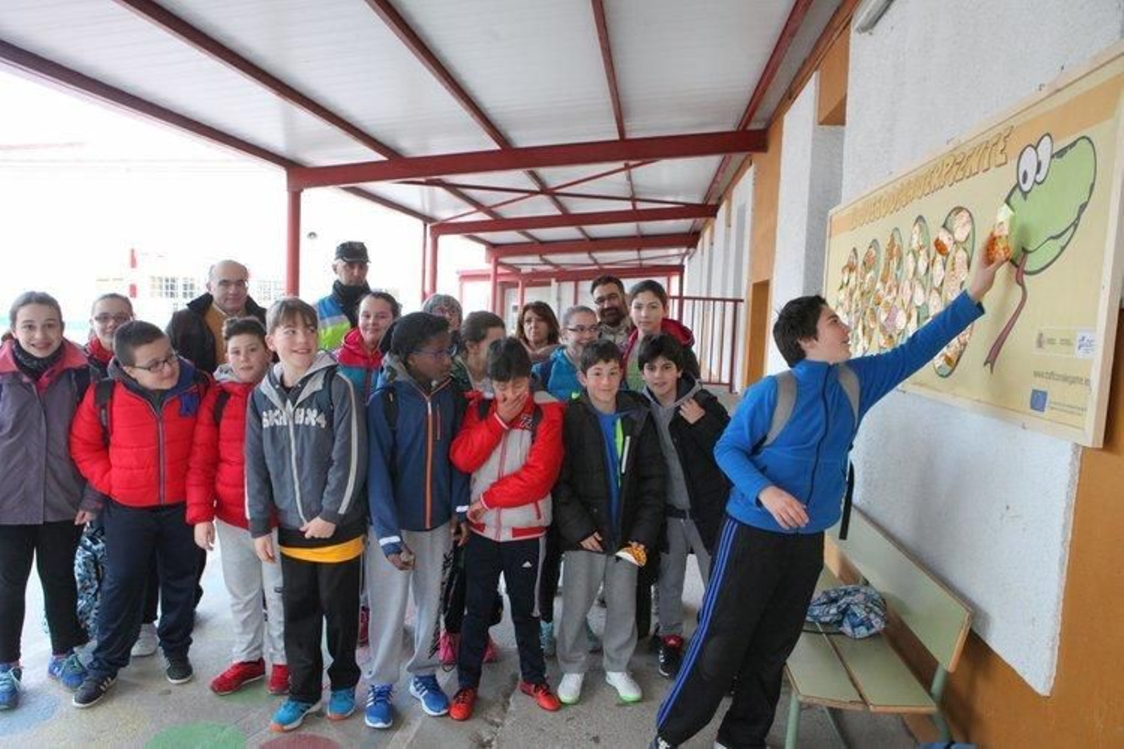 Los alumnos posan ante el mural que escenifica el juego de la serpiente