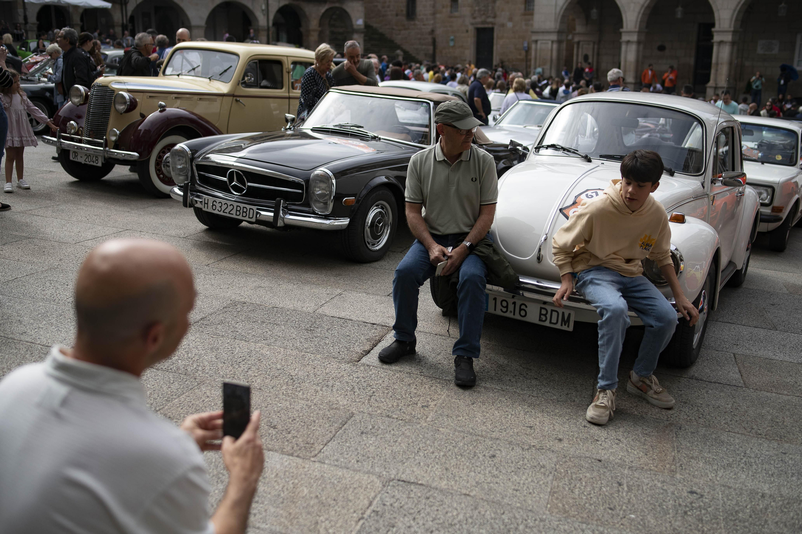 Dos personas sacándose una foto junto a un coche de rally clásico en Ourense