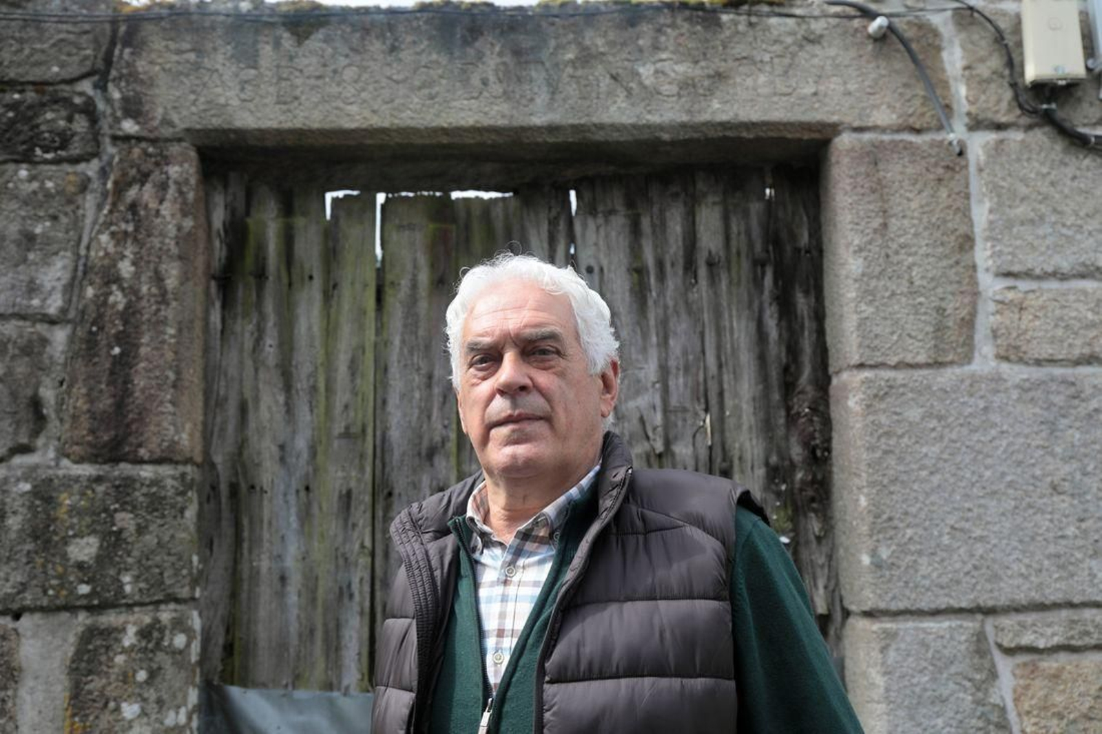 Ceferino Fernández posa frente a la fachada de la casa de Olín, en cuyo dintel se puede leer "Año 1850 Estanco Real" que fundó su bisabuelo. (Foto: José Paz)