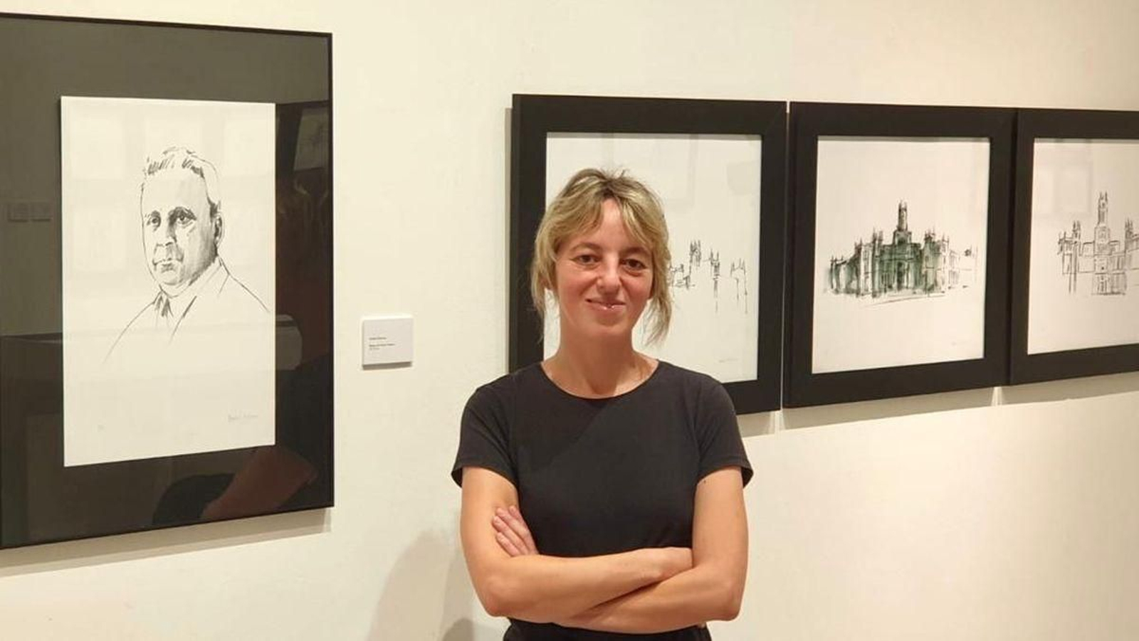 Amelia Palacios, autora de la exposición ‘Construir el paisaje’ junto a un retrato del arquitecto y varias de sus obras.