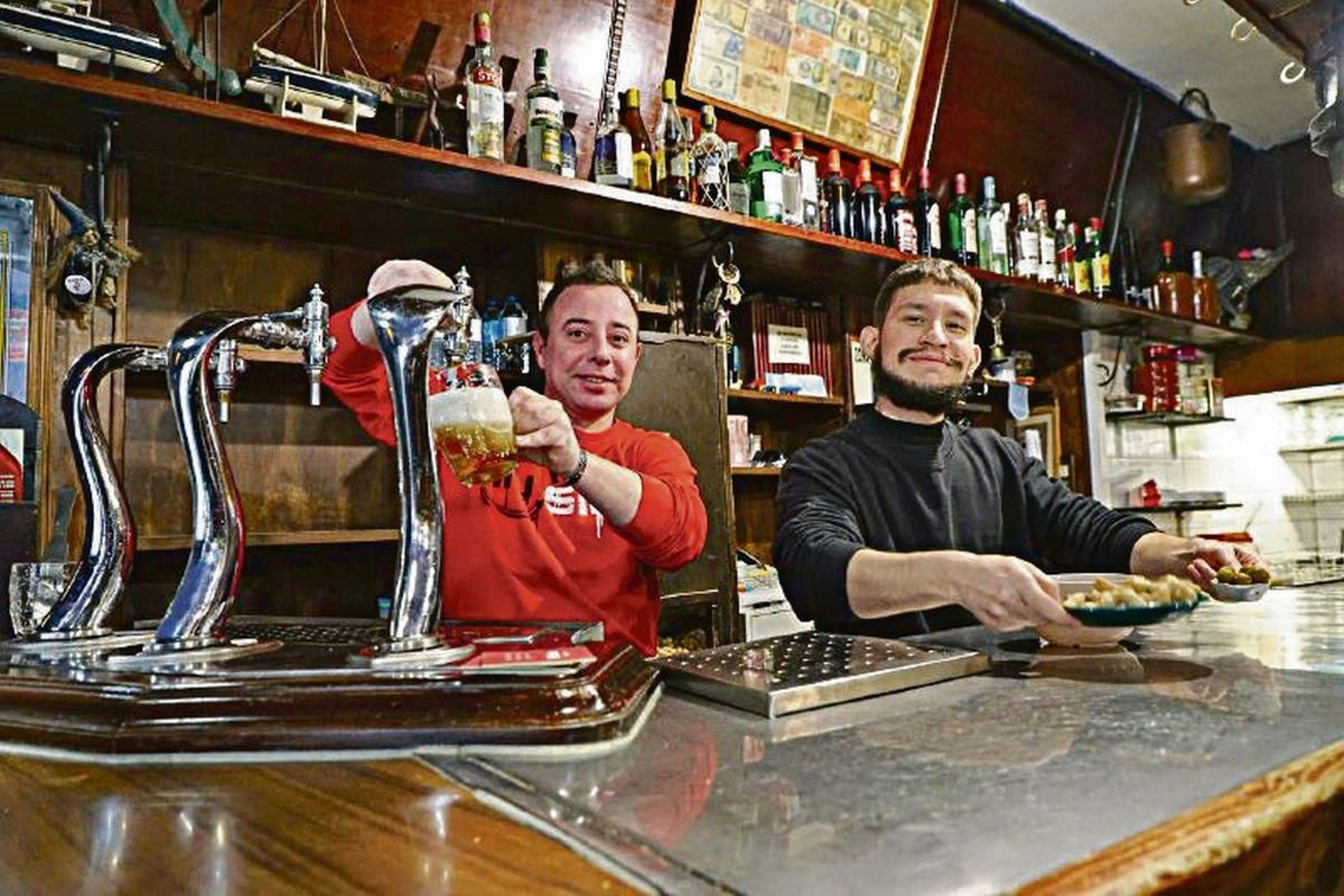 En la imagen, dos de los camareros de El Pasillo sirviendo cañas.