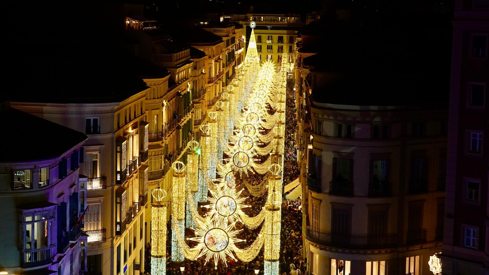 Una multitud camina bajo el alumbrado navideño en la época de fiestas