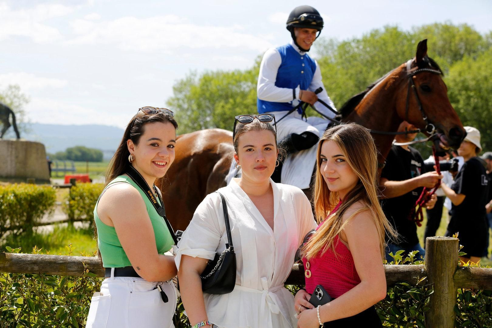 Tres aficionadas posando con uno de los corredores.