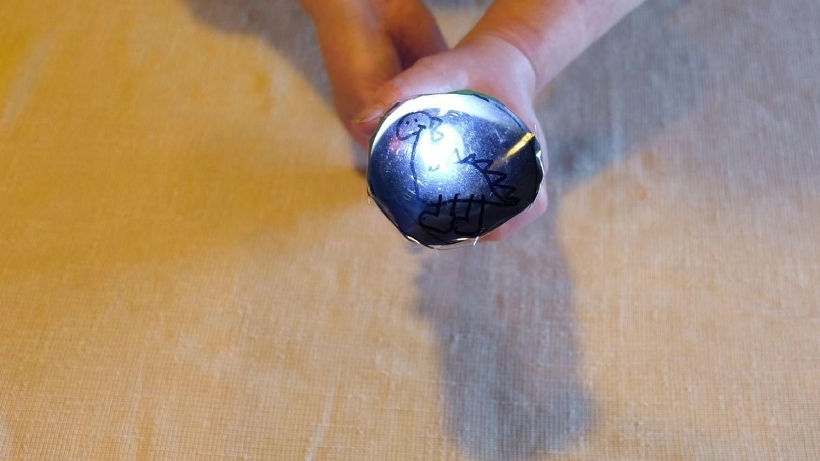 Xa case está listo o noso proxector caseiro. Agora só quedará que metas a lanterna polo burato máis estreito e a acendas. Xa verás cómo se ilumina o teu debuxo. Apaga a luz e crea as túas historias animadas sobre unha parede lisa. Podes proxectar todo o que se che ocorra. Xa sabes… Mans á obra!