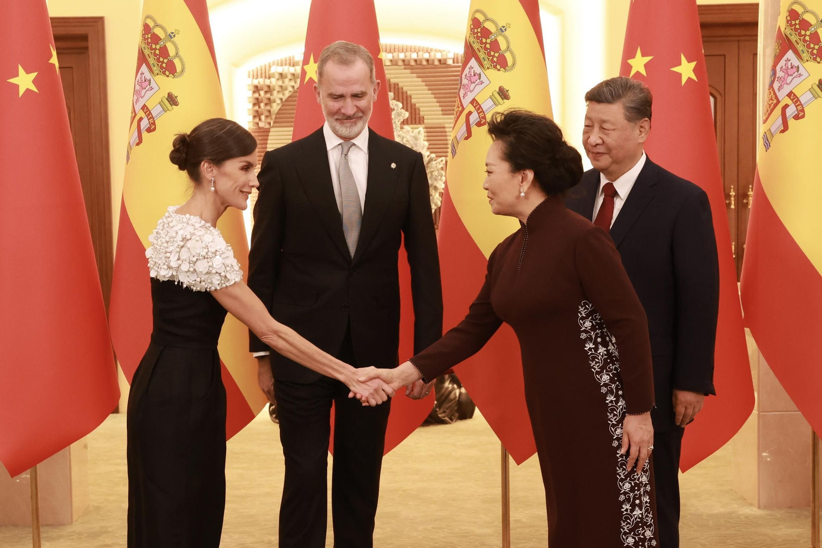 La reina Letizia saluda a la primera dama de China en presencia de Felipe VI y Xi Jinping.