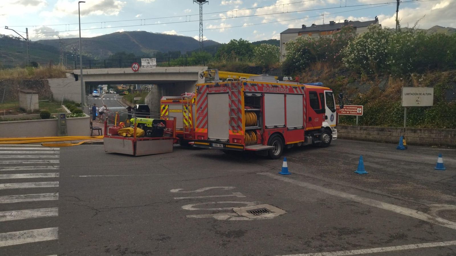 Los bomberos del parque de A Rúa achican agua del paso inferior de la vía del tren, en el acceso de la avenida Eulogio Fernández a la carretera N120.