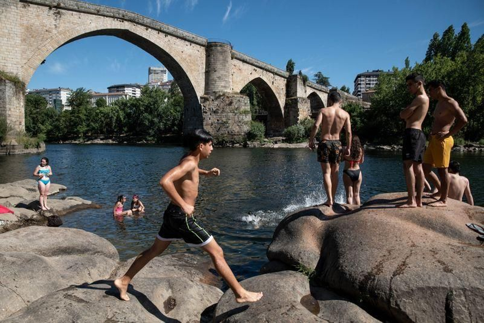 Un grupo de jóvenes se refresca en una zona del Miño, no autorizada para el baño (ÓSCAR PINAL).