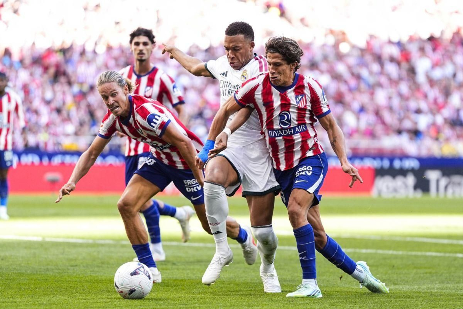 Kylian Mbappé disputa un balón con Marcos Llorente y Giuliano Simeone en el derbi del pasado domingo.