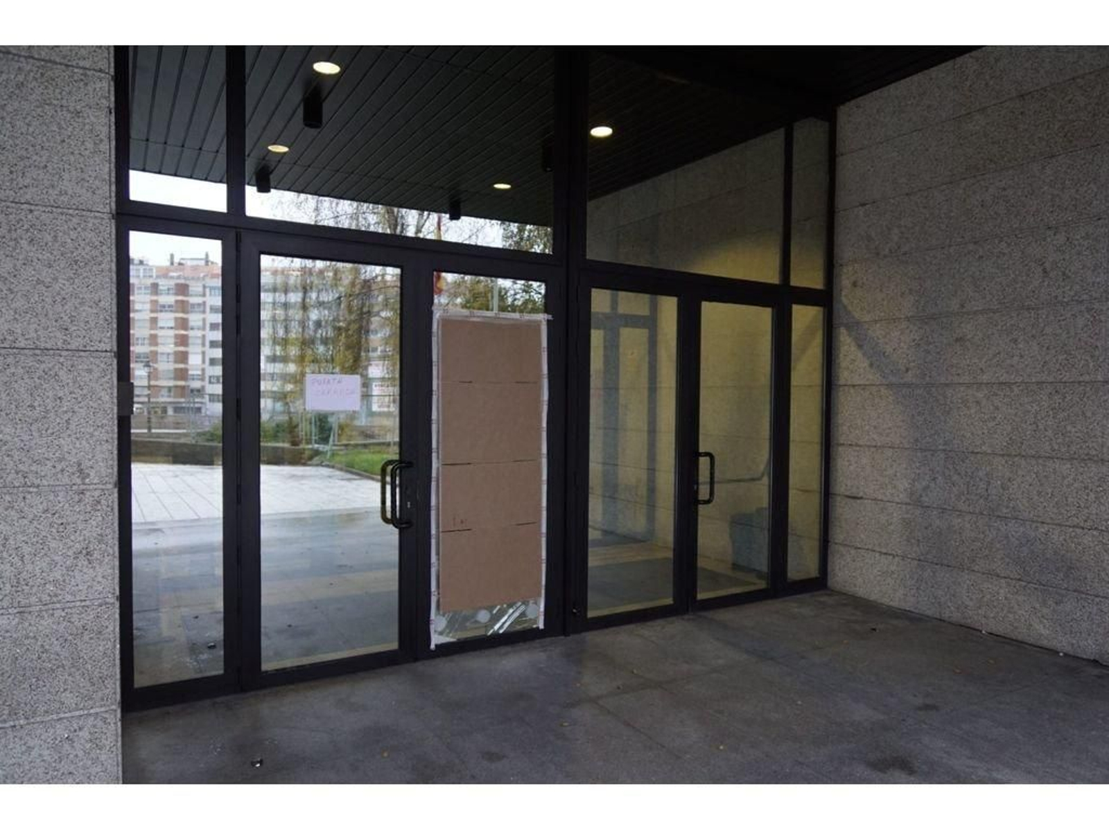 Un panel provisional tapaba ayer la fractura del cristal de la puerta de entrada.