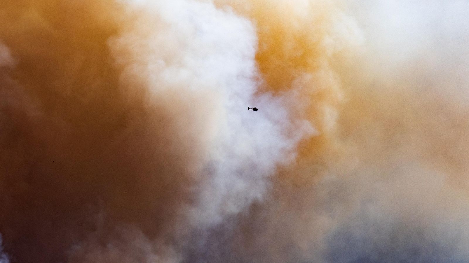 Un helicóptero sobrevuela en el humo del incendio, en La Bisbal d'Empordà.