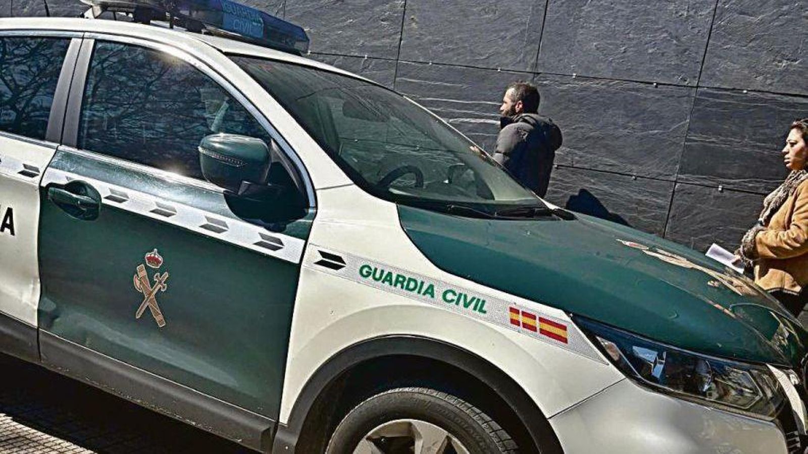 La pareja saliendo de los juzgados para entrar en el coche de la Guardia Civil.