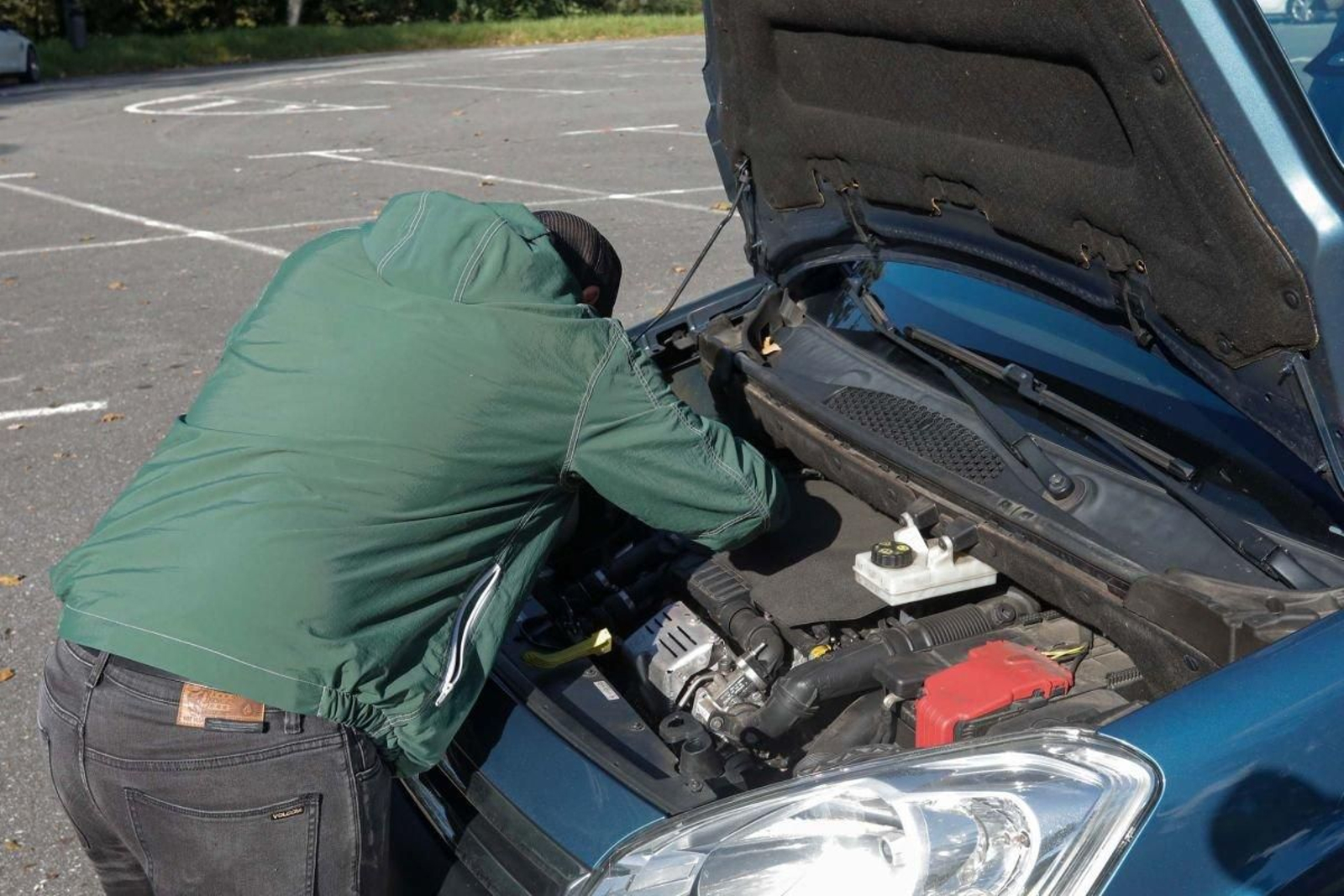 Un afectado revisando su vehículo que tiene un consumo excesivo de aceite.