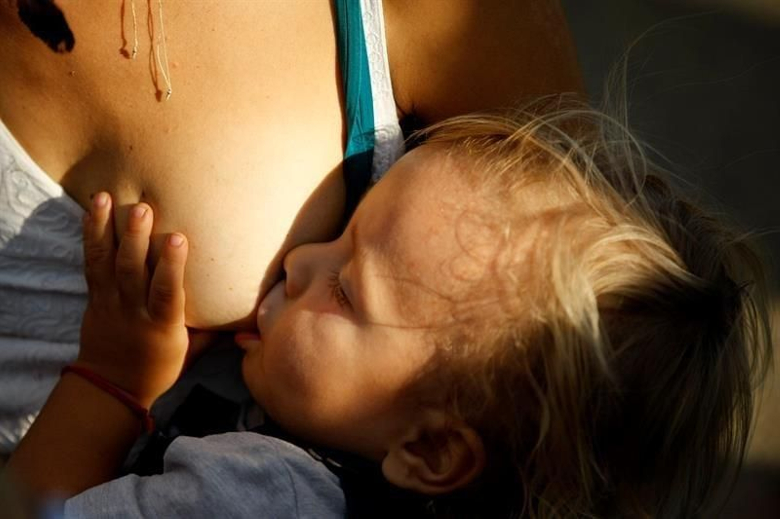 Una mujer dando el pecho a su bebé.