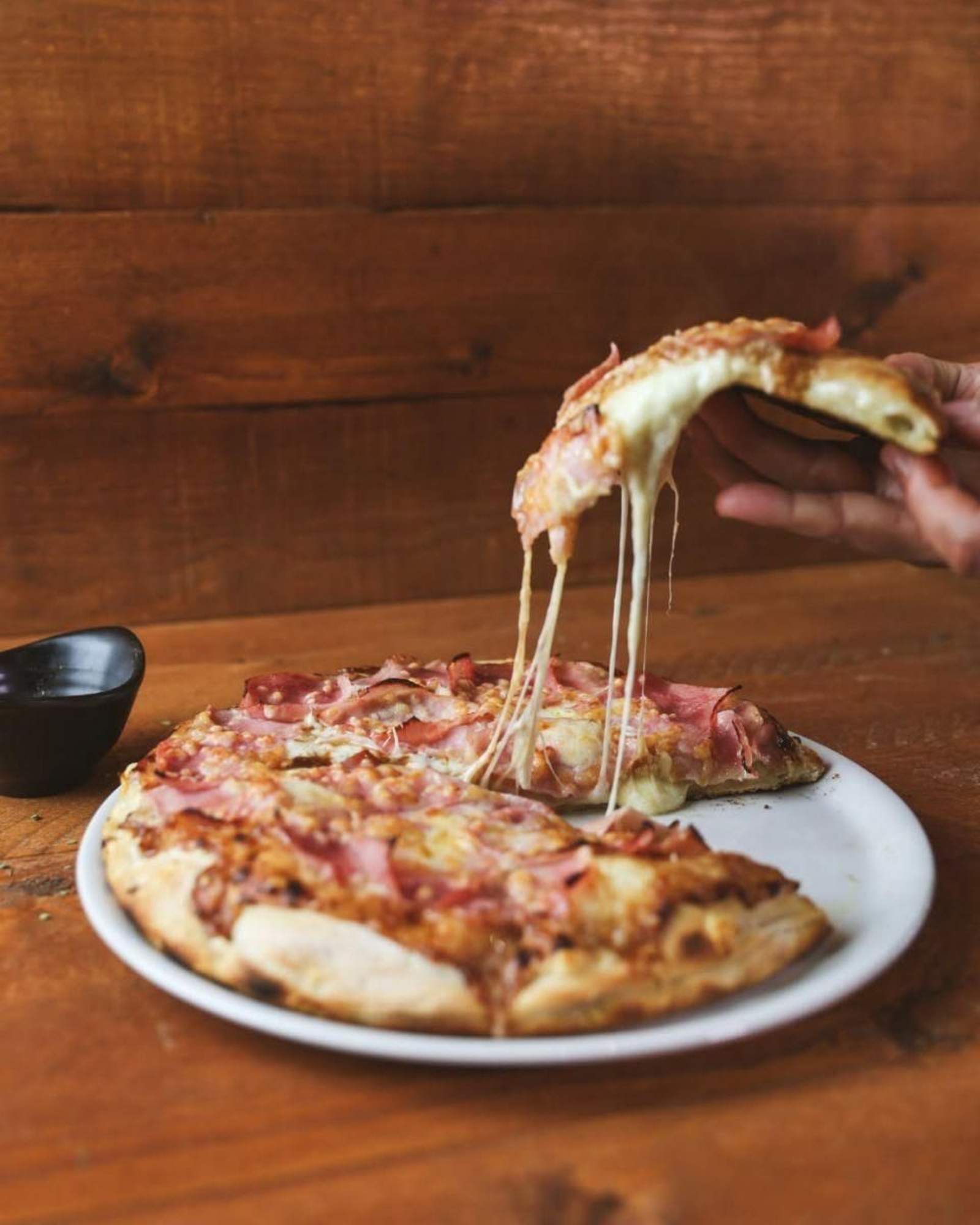 Queso fundido, el elemento clave: las rebanadas de las pizzas de Pizza Bonna son auténtico sabor italiano.