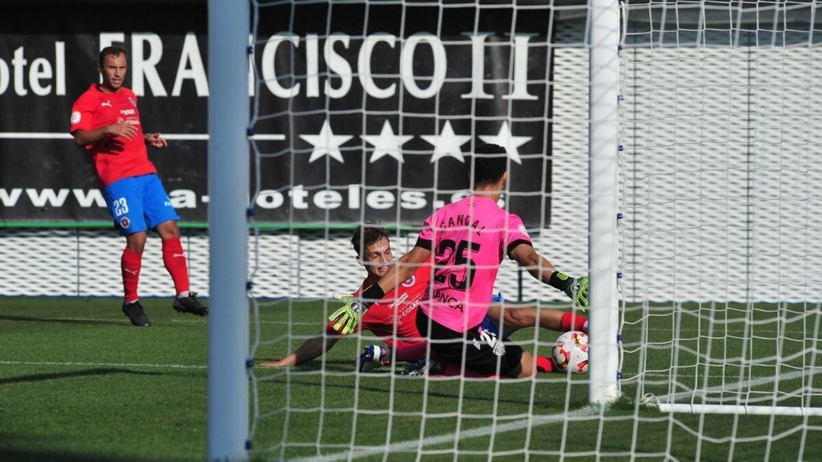Justino, extremo de la UD Ourense, lucha por un balón con el meta lucense Candal.