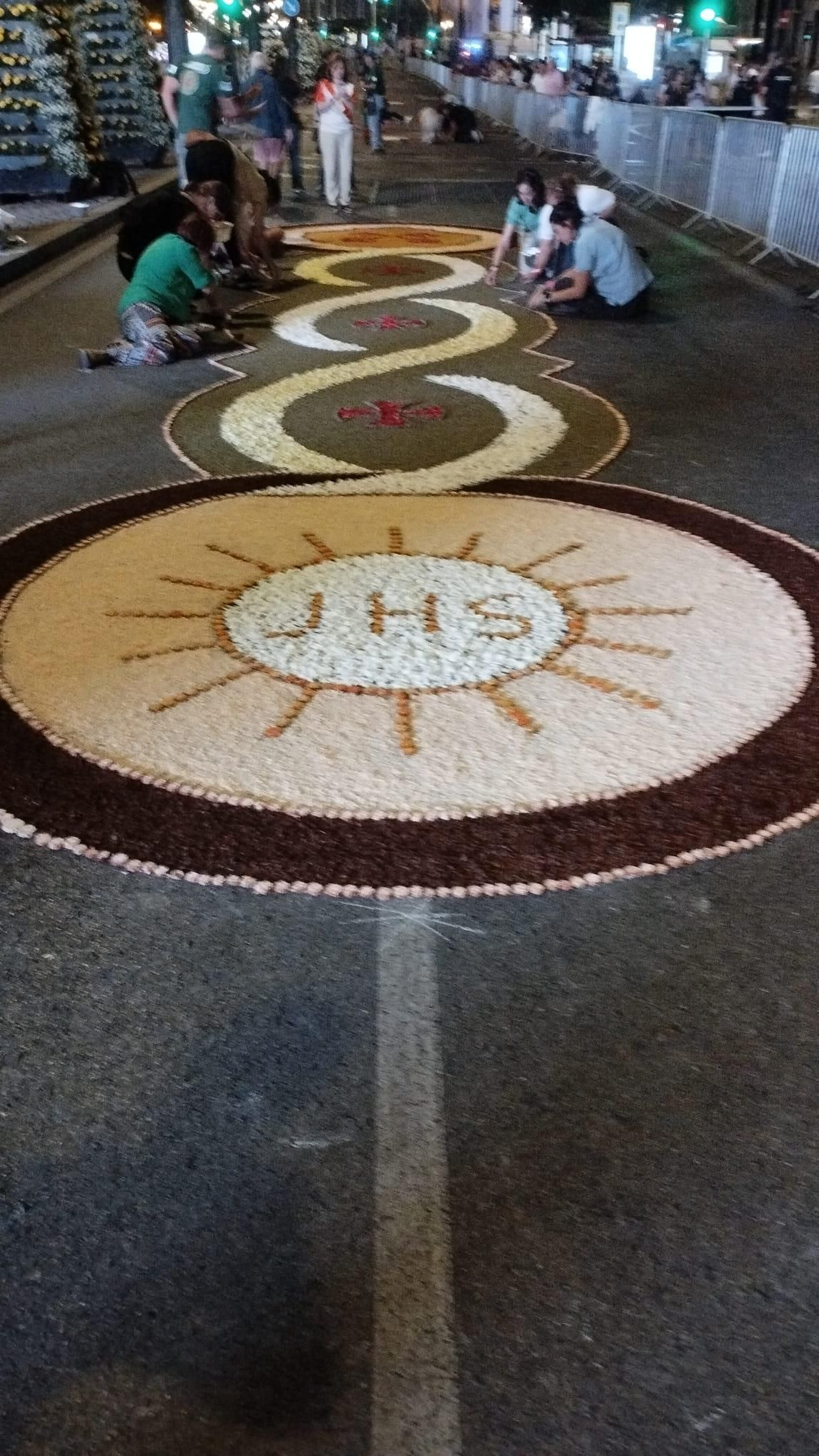 Voluntarios cuidando durante la noche las alfombras florales