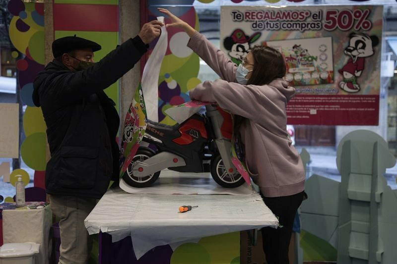 Una dependienta envuelve una moto correpasillos en la juguetería Din y Don de rúa Concordia. (FOTOS: MIGUEL ÁNGEL)