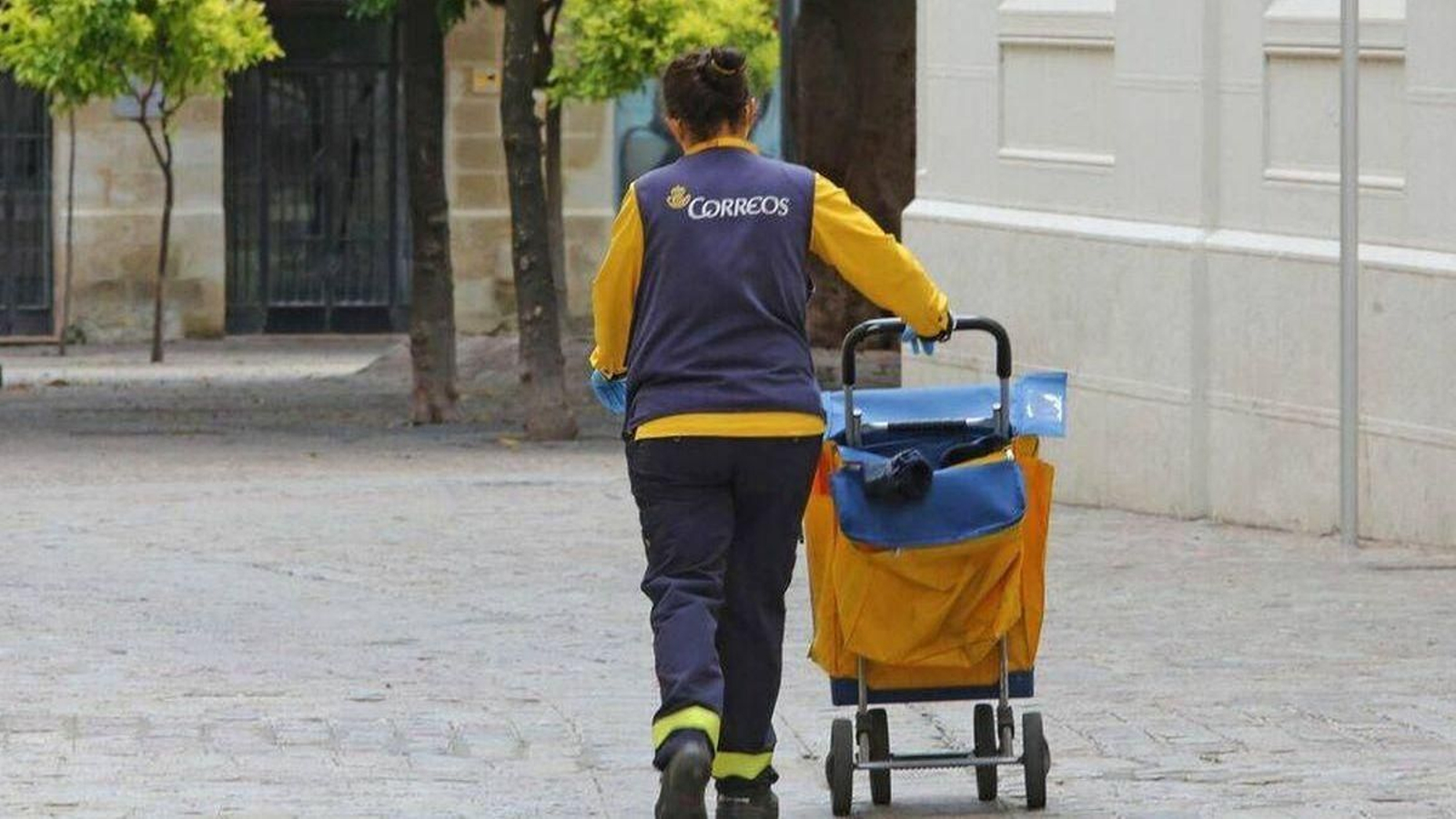Una trabajadora de Correos a pie.