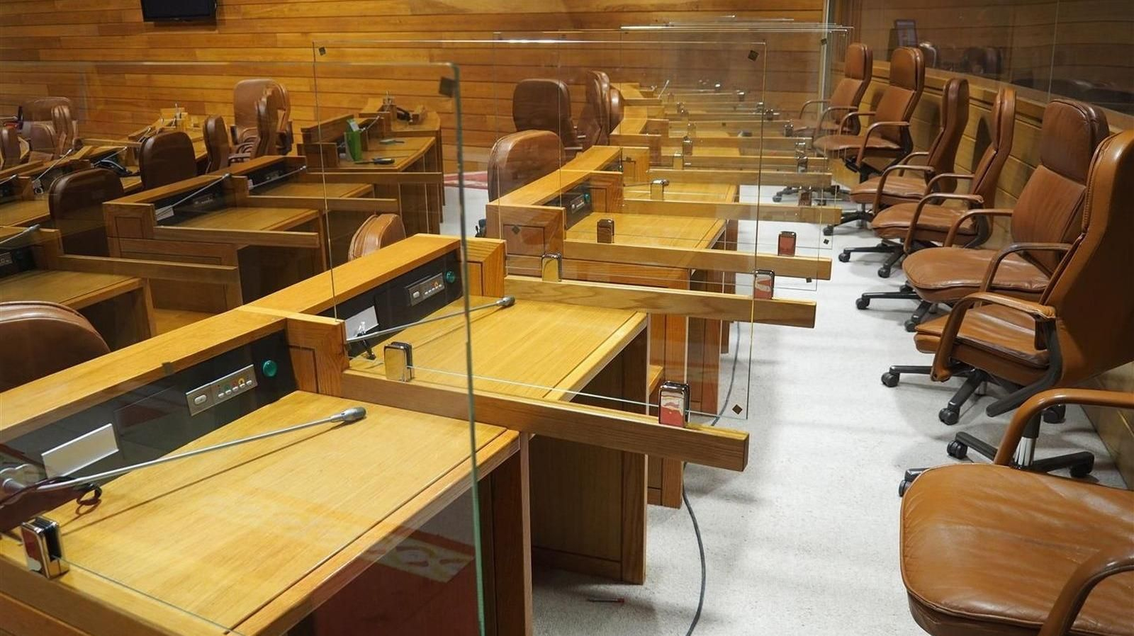 Entre las medidas covid, los escaños de cada parlamentario están divididos con mamparas.