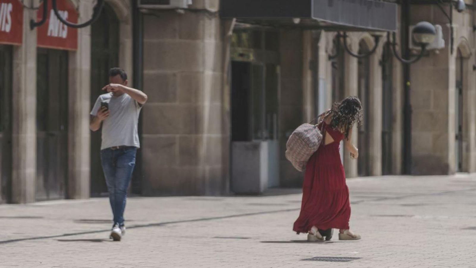 Dos personas caminando bajo el intenso calor de Ourense durante el verano.