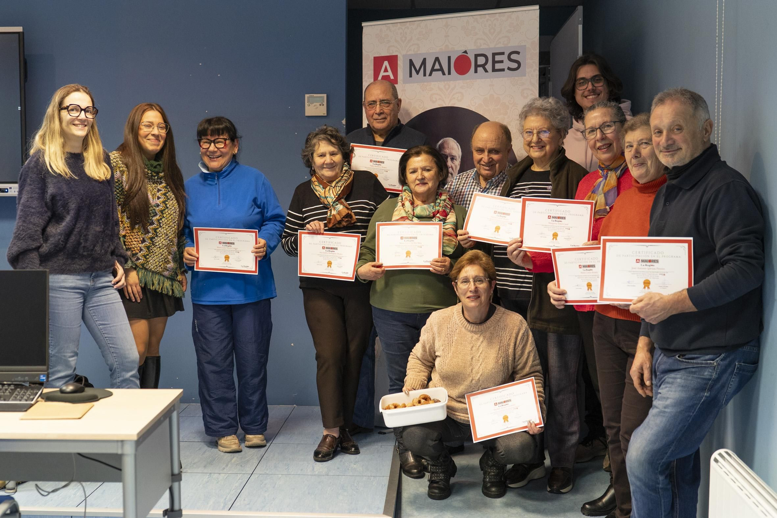 Los recién graduados posan con sus diplomas y la caja de rosquillas.