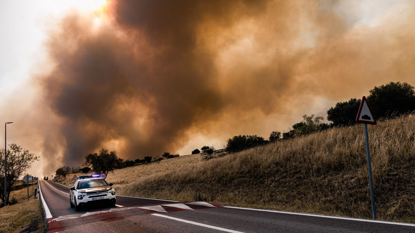 Un coche de la Guardia Civil vigila la evolución del fuego, a 23 de julio de 2026, en San Martín de Valdeiglesias, Madrid