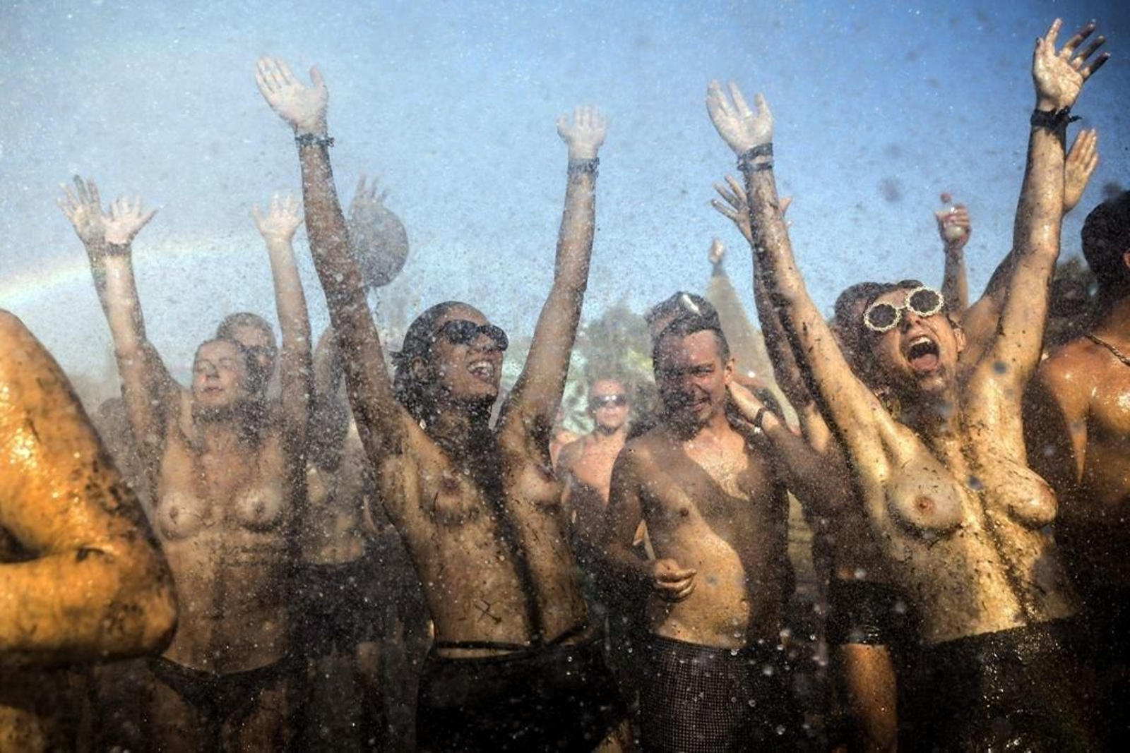 Chicos y chicas, rociados con agua para mitigar el calor, bailan al ritmo de la música psicodélica en Hungría.