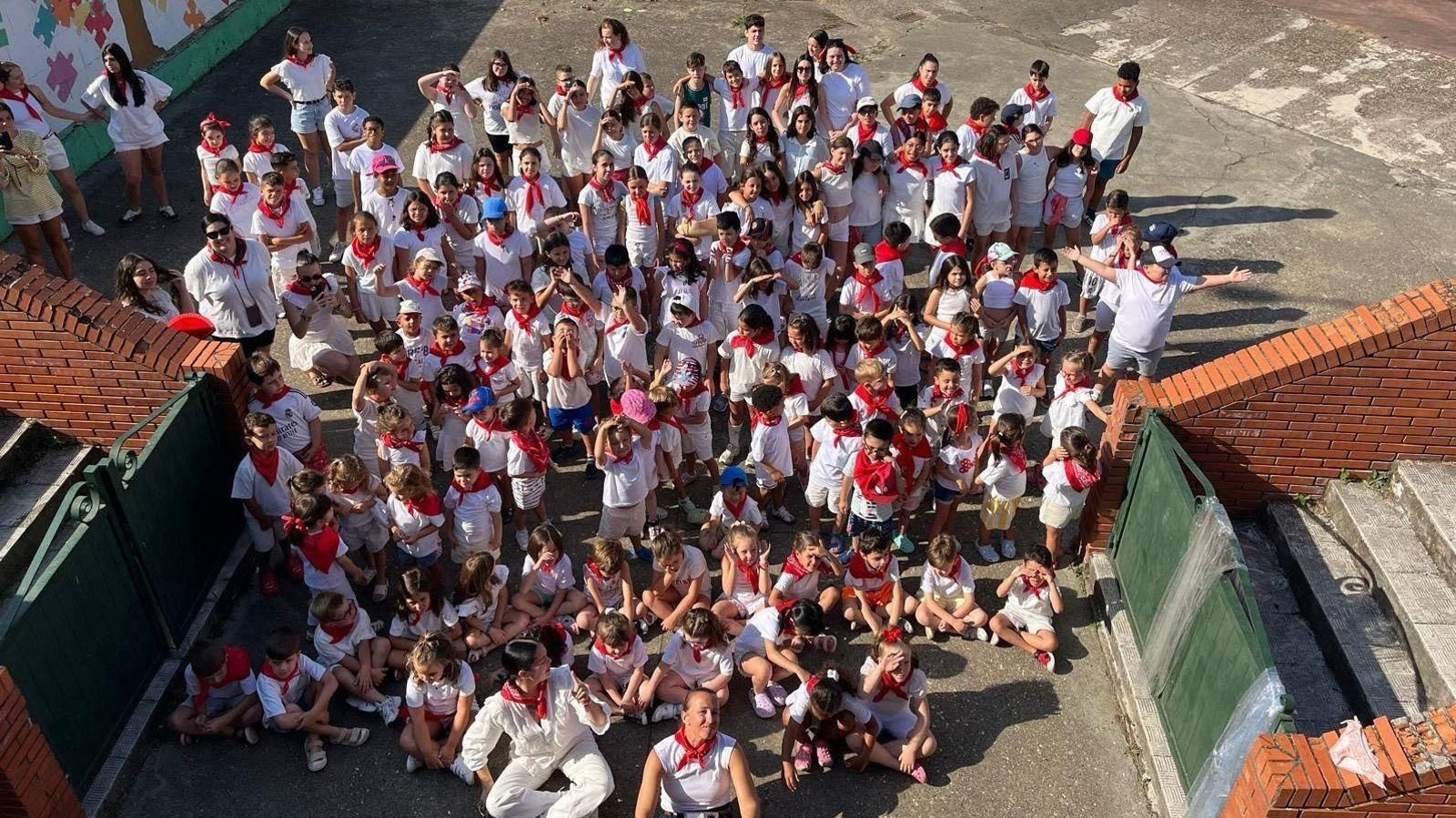 Foto de familia de los jóvenes participantes en la ludoteca de Verín, ataviados como en San Fermín.