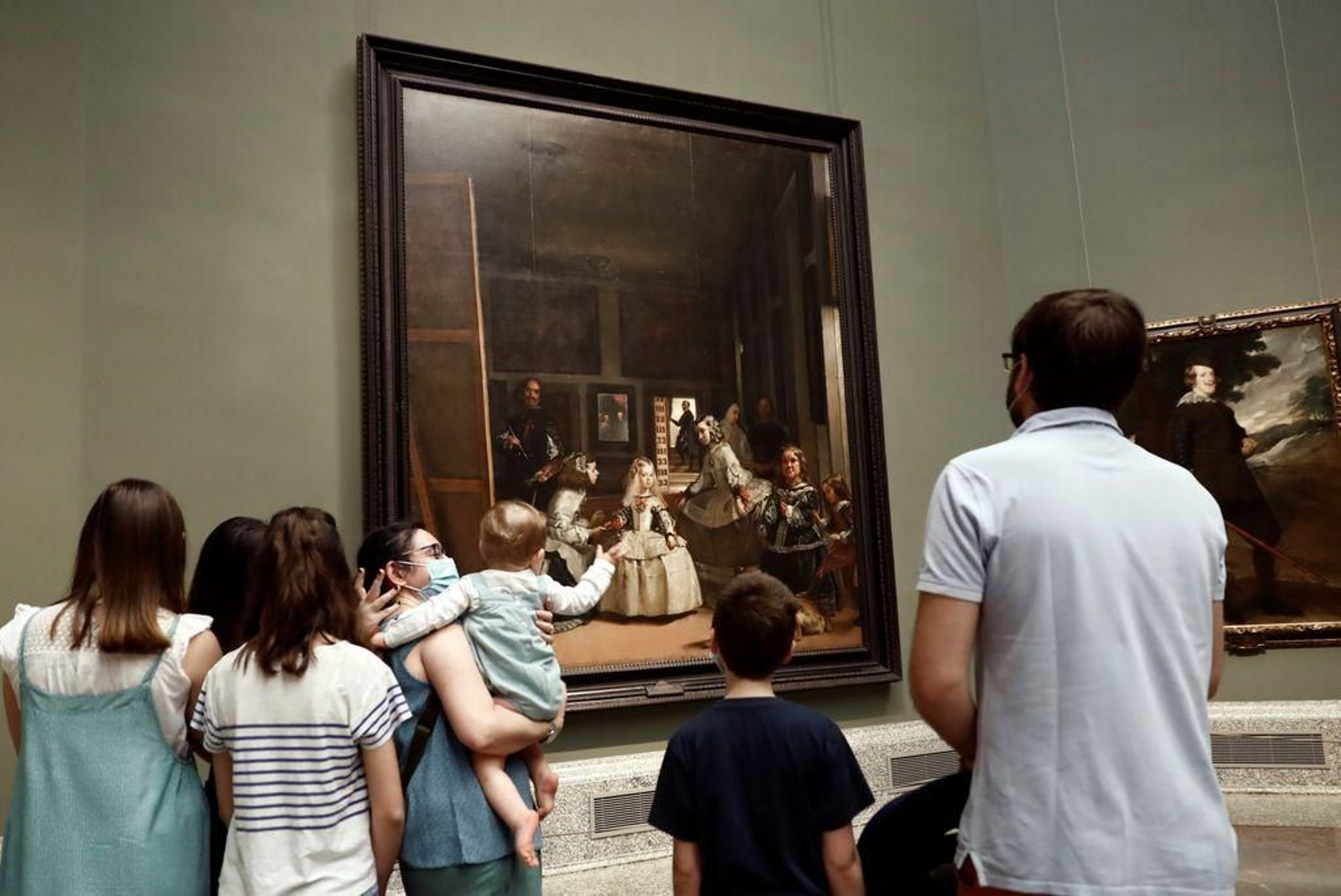 Varias personas admiran "Las meninas" de Velázquez expuesto en el Museo del Prado en Madrid.