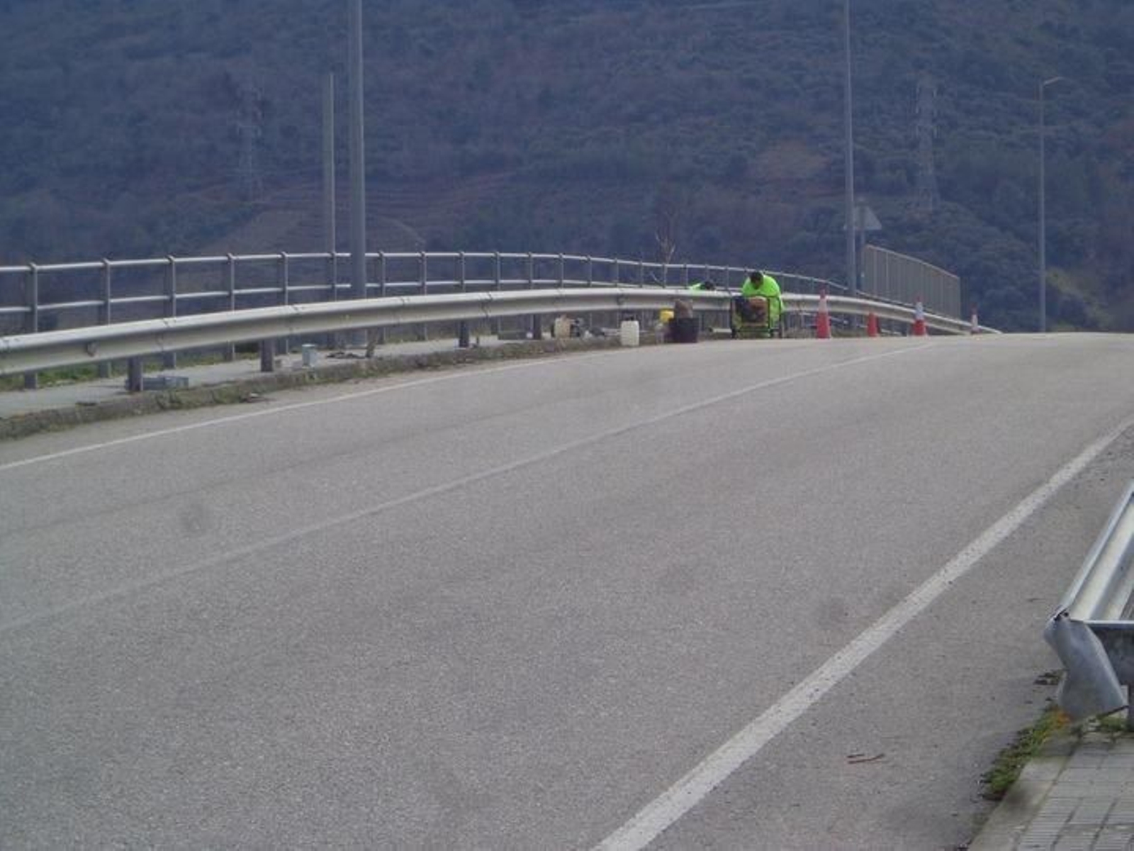 Dos trabajadores arreglan el tramo de bionda dañado.