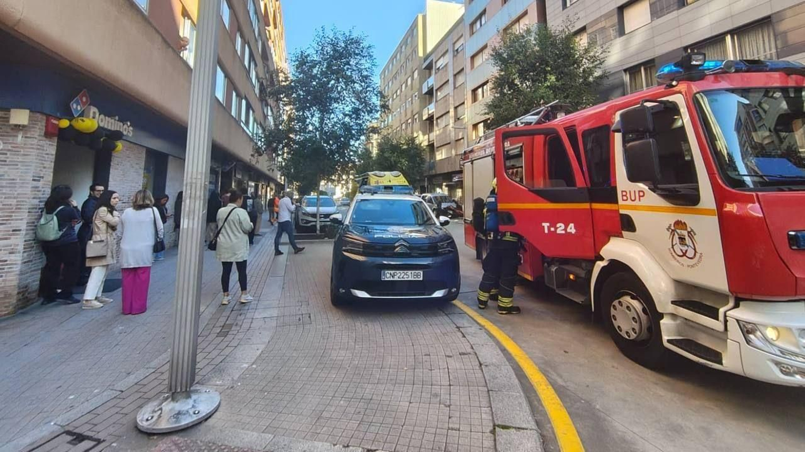 Trabajadores de las oficinas esperando en la calle tras el incendio.
