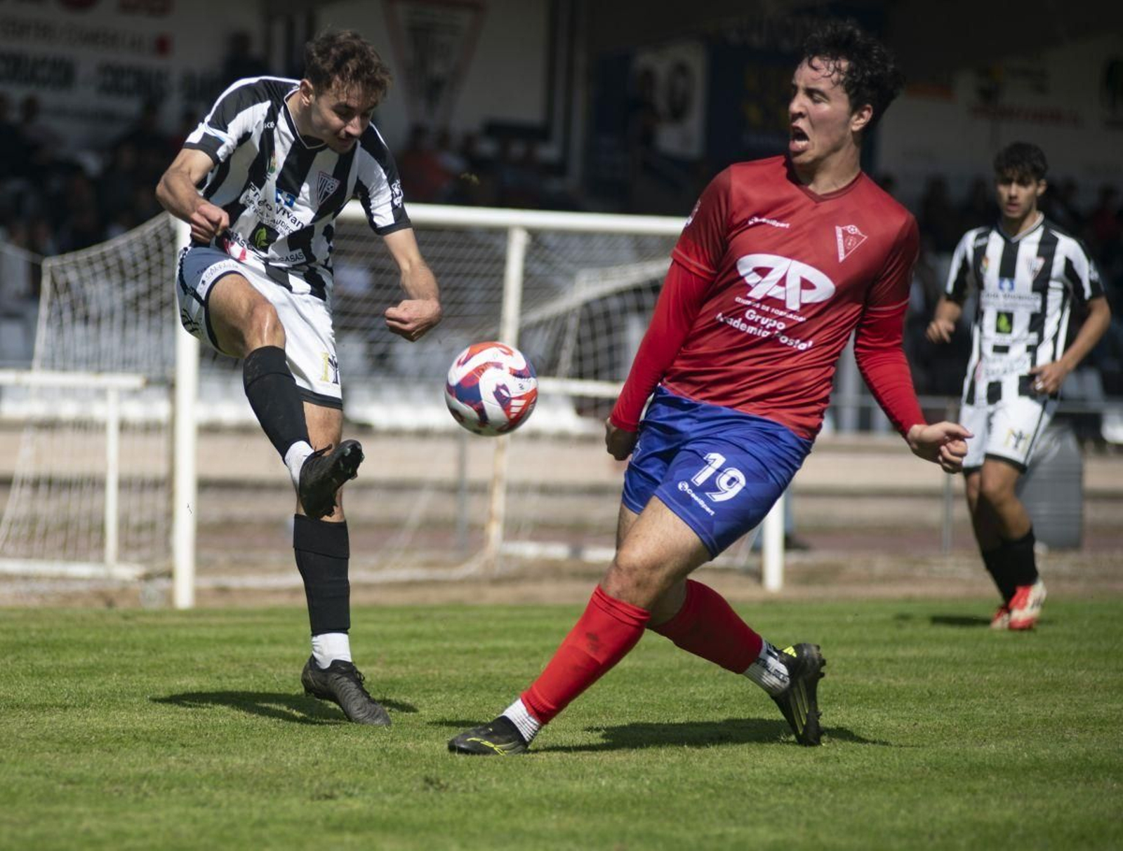 El macedano Mario Gómez intenta interceptar el centro de David Lamas, del Antela.