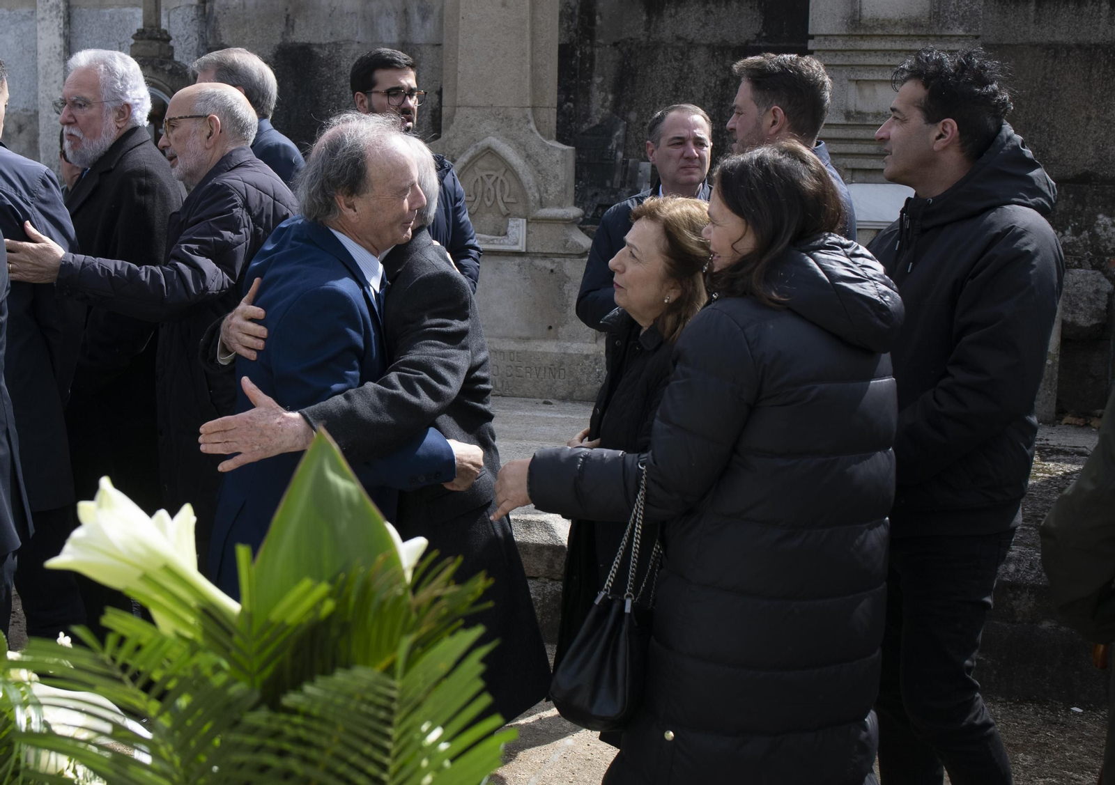 Eduardo López, presidente de la Fundación Otero Pedrayo, recibe un abrazo durante la ofrenda floral al intelectual en su tumba en el Cementerio de San Francisco.