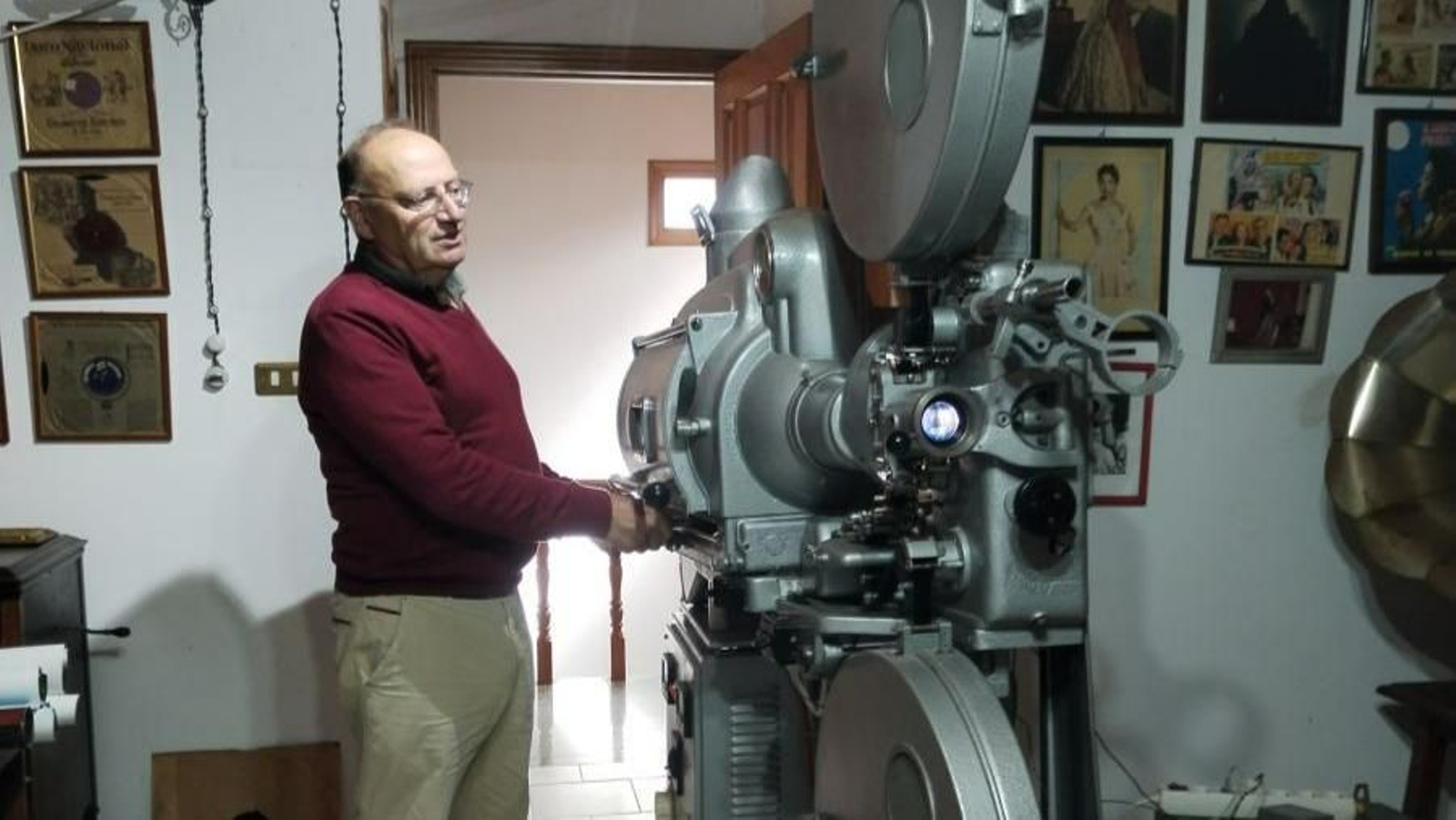 Ernesto Romero junto a uno de sus proyectores antiguos
