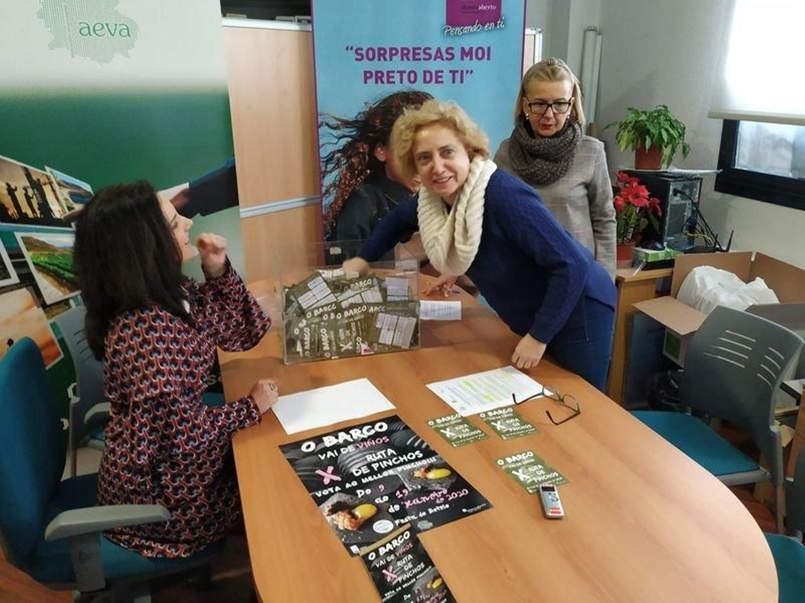 Araceli Fernández extrae una cartilla, ante María Ángeles Rodríguez e Irene Dacal. (J.C.)