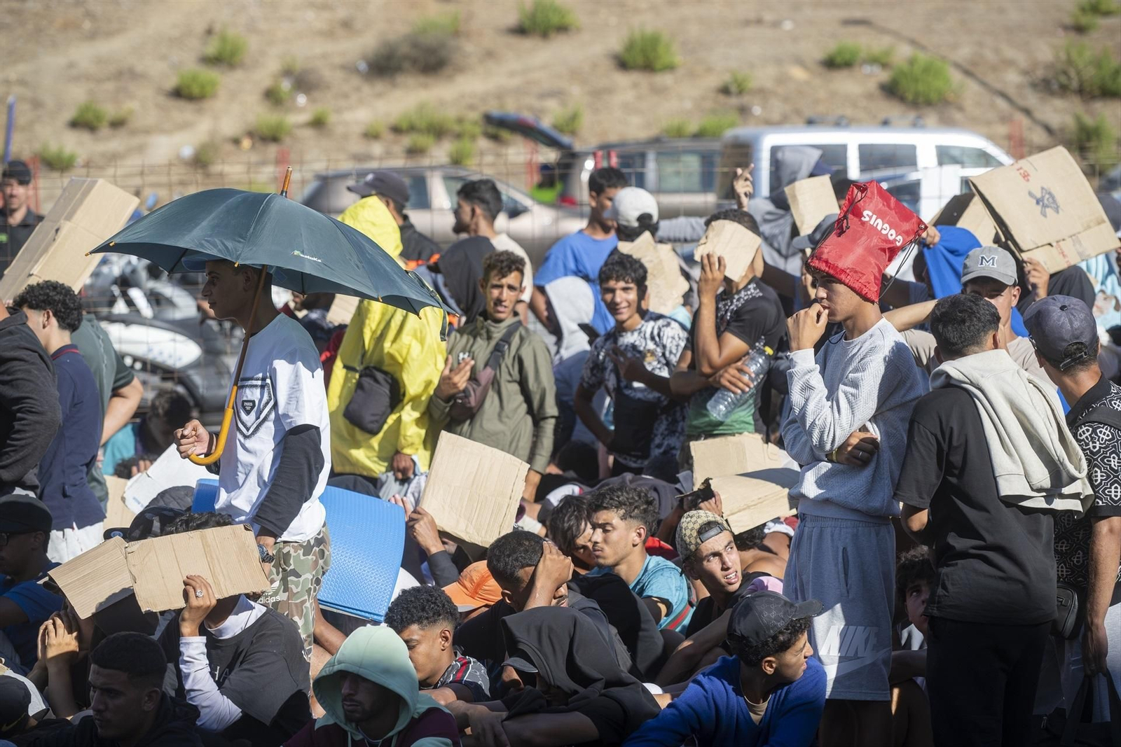 Migrantes esperan en una cola en Ceuta.
